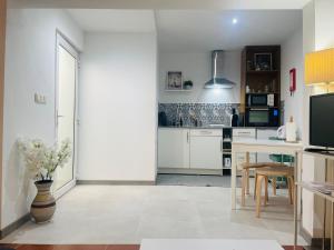 a kitchen with white cabinets and a table with a vase of flowers at Casa Nunes 2 in Pinhão