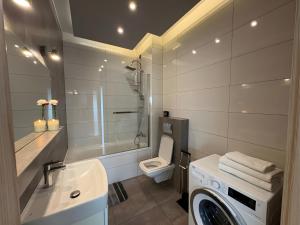 a bathroom with a sink and a washing machine at Apartamenty Mariańska 103 in Racibórz +25 photos