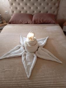 a bed with towels on it with a candle on it at Apartment Aleksandrija in Niš
