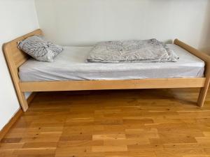 Posto letto in camera con pavimento in legno. di Malmi Home a Vaasa