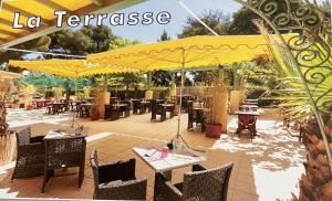 a patio with tables and chairs and yellow umbrellas at MOBIL HOME 200m de la mer in Hyères