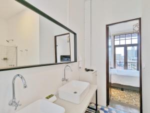 ein weißes Badezimmer mit zwei Waschbecken und einem Spiegel in der Unterkunft Donovan By Wynwood House in Panama-Stadt + 100 Fotos