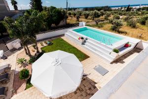 an overhead view of a swimming pool with an umbrella and a swimming pool at B&B Villa Noemi in Porto Cesareo