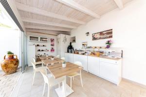 a kitchen and dining room with a wooden table and chairs at B&B Villa Noemi in Porto Cesareo