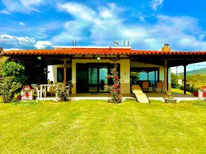 a house with a patio and a table in the grass at Villa Sea Esta in Maronia