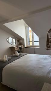 ein Schlafzimmer mit einem großen Bett und einem Spiegel in der Unterkunft Appartement charmant et cosy Encombe vineuse-DABNB in Limoges