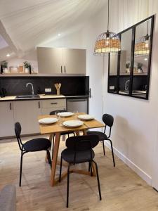 eine Küche und ein Esszimmer mit Tisch und Stühlen in der Unterkunft Appartement charmant et cosy Encombe vineuse-DABNB in Limoges + 19 Fotos