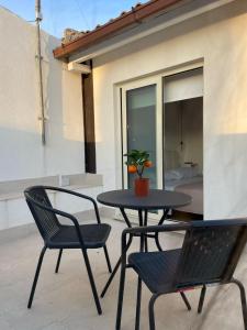 a patio with a table and two chairs and a potted plant at AZ rooms in Noto