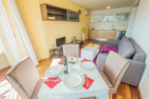 Apartments Villa Dinka في أوباتيا: غرفة معيشة مع طاولة وأريكة