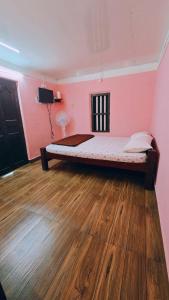 a bedroom with a bed in a pink wall at Coffeeisland vintage stay in Meenangadi