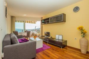 a living room with a couch and a tv at Apartments Villa Dinka in Opatija
