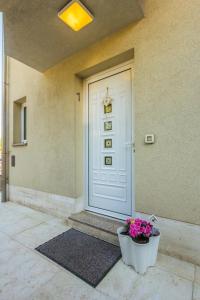 a front door of a house with a pot of flowers at Apartments Villa Dinka in Opatija