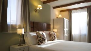 una camera da letto con un letto bianco e una finestra di Panorama Guest House ad Alghero