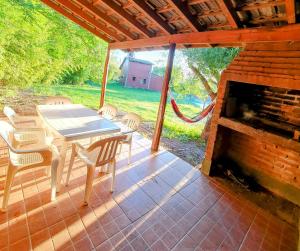 a patio with a table and chairs and a fireplace at Cabañas Pioneras in Villa Rumipal +48 photos