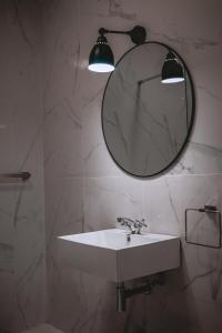 a bathroom with a sink and a mirror on a wall at Beachfront Apartment 1 in St Paul's Bay