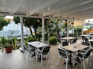 a patio with tables and chairs on a patio at Harilla Hotel in Dhërmi