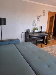a bedroom with a bed and a table and a piano at DREAMSVILLE in Ventspils