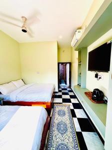 a hotel room with two beds and a tv at Narayana's Haveli in Varanasi