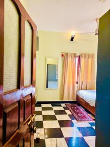 a bedroom with a bed and a checkerboard floor at Narayana's Haveli in Varanasi +32 photos