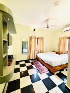 a bedroom with a bed and a checkered floor at Narayana's Haveli in Varanasi