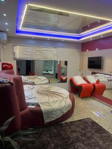 a room with beds and a couch and a tv at Motel Blue Star II in Campo Mourão