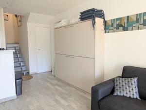 a living room with a couch and a closet at Centre ville, studio vue port, avec parking privé in La Grande-Motte