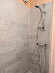 a shower with white marble walls and a shower head at Centre ville, studio vue port, avec parking privé in La Grande-Motte