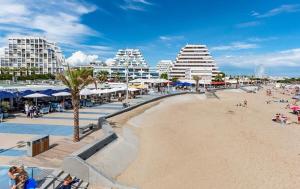 a beach with people and hotels and buildings at Centre ville, studio vue port, avec parking privé in La Grande-Motte