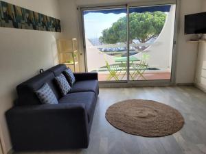 a living room with a couch and a large window at Centre ville, studio vue port, avec parking privé in La Grande-Motte +14 photos
