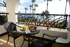 a table with a plate of food on a balcony at Jennyville Pension in Seogwipo