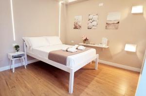 a bedroom with a white bed with two towels on it at Il Vico del Greco B&B in Le Castella +79 photos