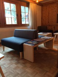 uma sala de estar com um banco e uma mesa com discos em Hotel Ducan em Monstein