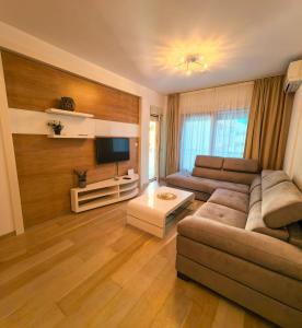a living room with a couch and a tv at Azure Horizon Pržno in Sveti Stefan +9 photos