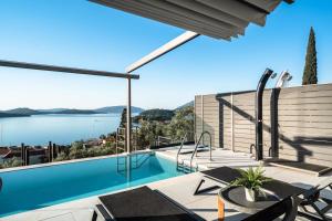 a house with a swimming pool and a view of the water at Villa Scorpios View in Nydri