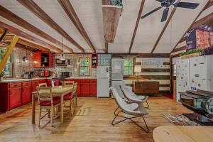 a kitchen with red cabinets and a table and chairs at River Walk Cottage - Romantic Escape in Great Cacapon
