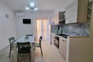a kitchen with a table and chairs and a kitchen with a dining room at Alice Apartment in Tropea