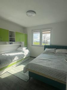 a bedroom with two beds and a window at Aqua Verde Sarajevo in Nišići +15 photos