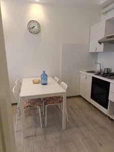 a kitchen with a table and a clock on the wall at Sole e mare in Porto SantʼElpidio