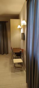a dining room with a table and chairs and a television at Andros Guesthouses in Andros