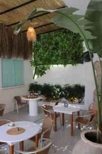 un ristorante con tavoli e sedie bianchi e una pianta di Luvenza Hotel Alaçatı a Çeşme Altre 16 foto
