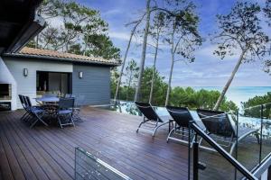 a wooden deck with a table and chairs on it at Villa-SONNIER-Biscarrosse in Biscarrosse