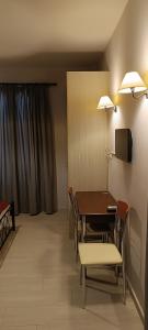 a room with a table and chairs and a television at Andros Guesthouses in Andros