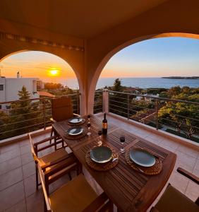 a table on a balcony with a view of the ocean at Unick Seaview Luxury Living in Kalathas
