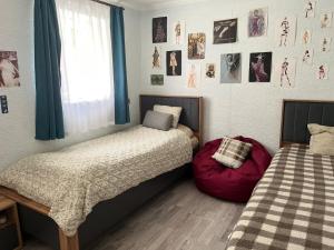 2 camas en un dormitorio con fotos en la pared en Cozy Tbilisi Home, en Itʼkhvisi