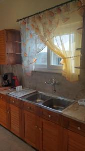 a kitchen with a sink and a window at Apartment Dolphins in Plomarion +60 photos