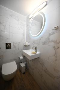 a bathroom with a sink and a toilet and a mirror at Unick Seaview Luxury Living in Kalathas +37 photos