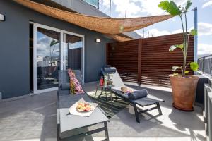 a patio with a table and chairs on a balcony at Anele Luxury Suites - Roof Top Jacuzzi in Chania