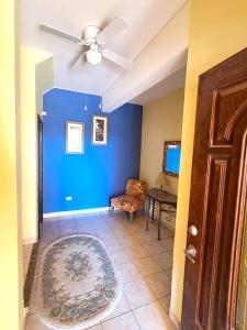 een woonkamer met een plafondventilator en een blauwe muur bij Villa Hermosa Ocean View 2 Bed in San Carlos
