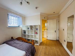a bedroom with a bed and a room with a closet at Charming 2 Bedroom Flat with Urban Views in Romford