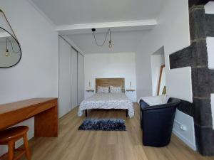 a white room with a bed and a piano at Victórias in Porto Formoso
